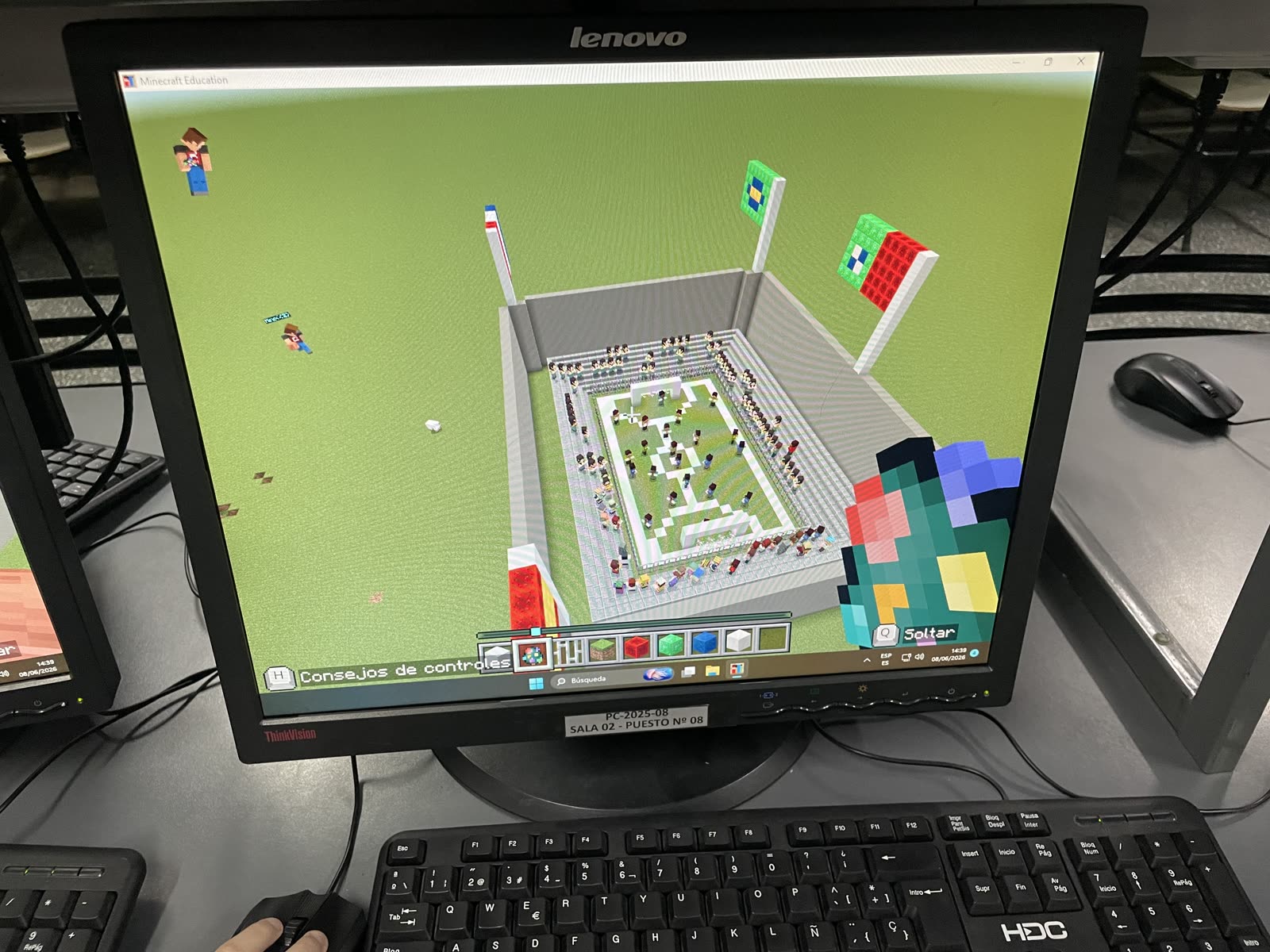 Estadio de fútbol con tribunas y público construido en Minecraft Education